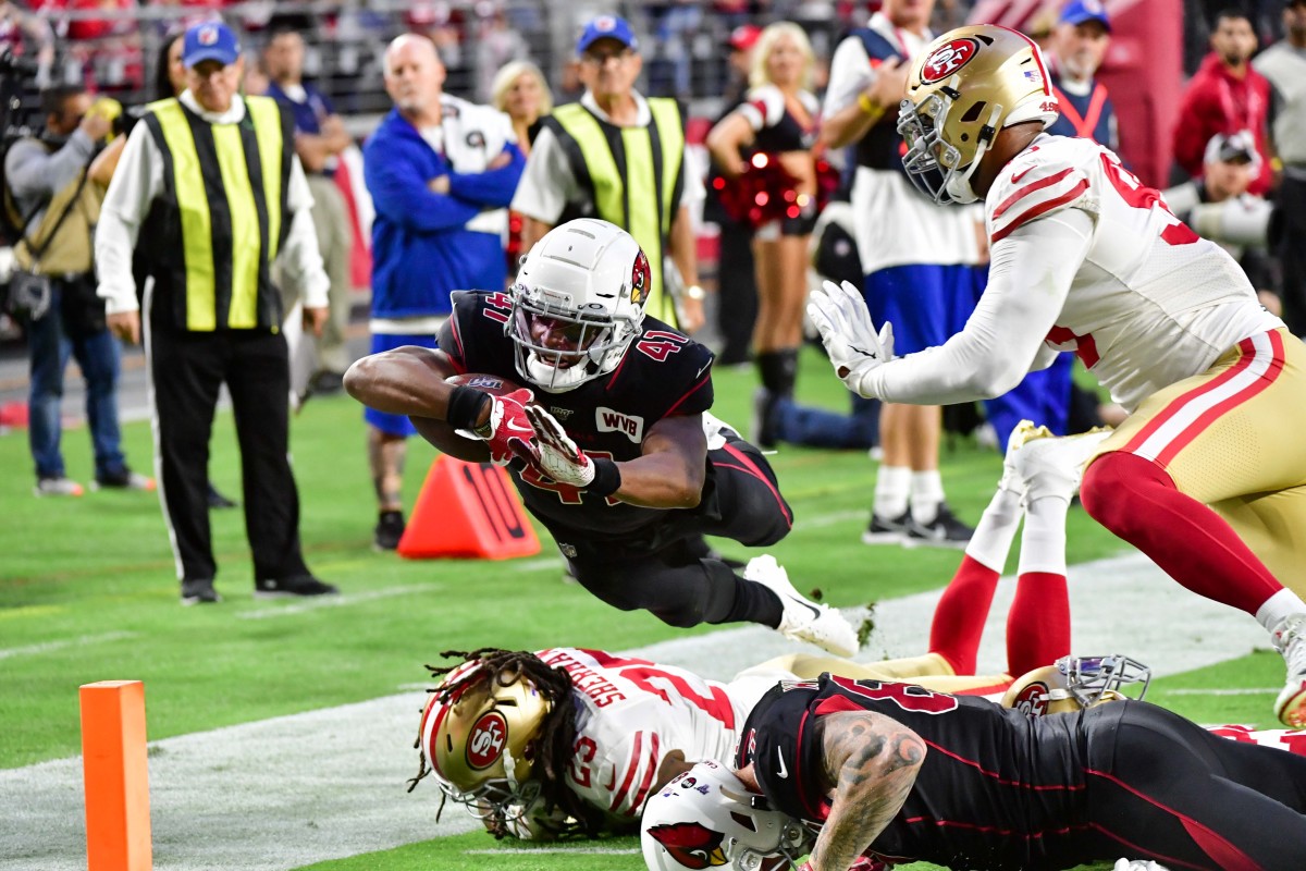 Cardinals running back Kenyan Drake dives over 49ers cornerback Richard Sherman to score a touchdown in a 2019 game at State Farm Stadium. 